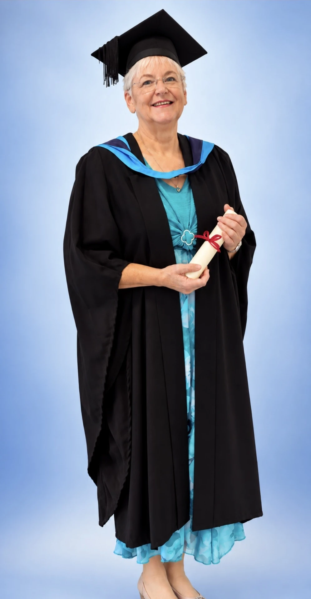Sally in her graduation gown and cap, holding her certificate